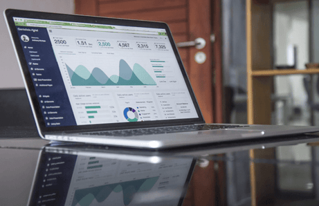 Laptop with business analysis pie charts