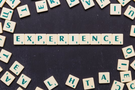 Top view of experience text with scrabble letters over black backdrop Free Photo